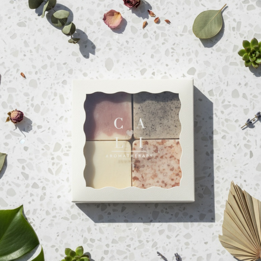 Four-piece Cali Cealn soap set in a box with 'Cai' branding on a textured surface with decorative leaves.