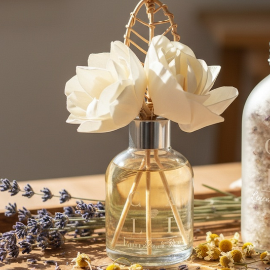 Glass diffuser bottle with wooden flowers and lavender on a wooden surface