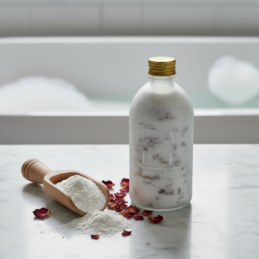 Bottle of foaming coconut milk bath product with a scoop of powder and rose petals on a marble surface.