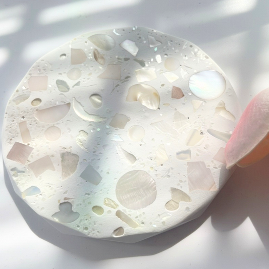 Round decorative coaseter with shell patterns on a white background