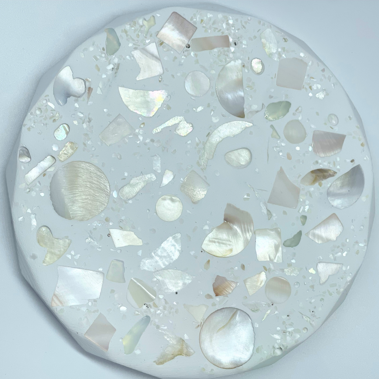 Round decorative item with shell on a light gray background