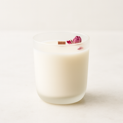 white frosted glass wit ha wooden wick and pink rose in a white background